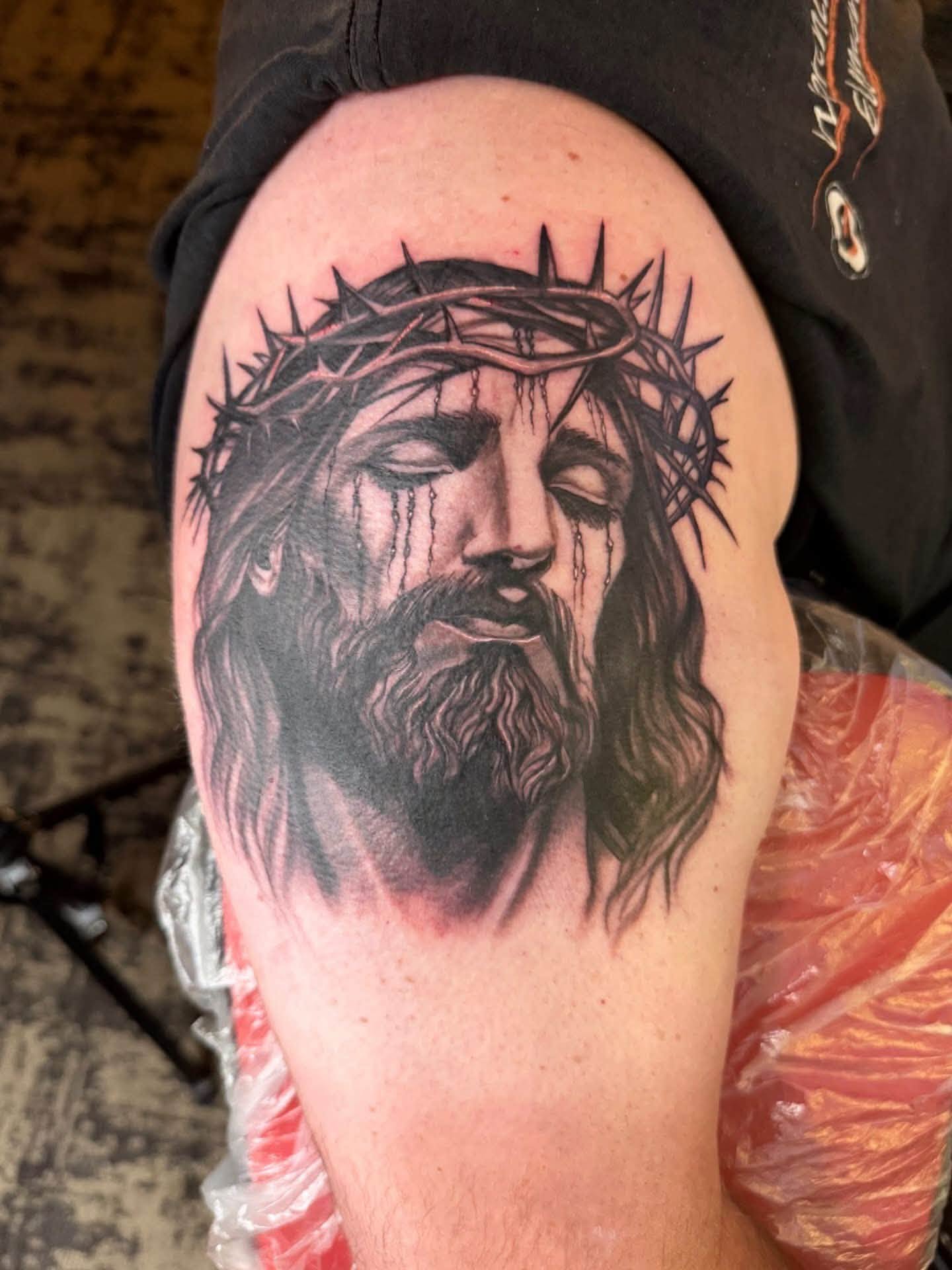 Black-and-gray portrait of Jesus with a crown of thorns, tattooed by Joseph Rojas